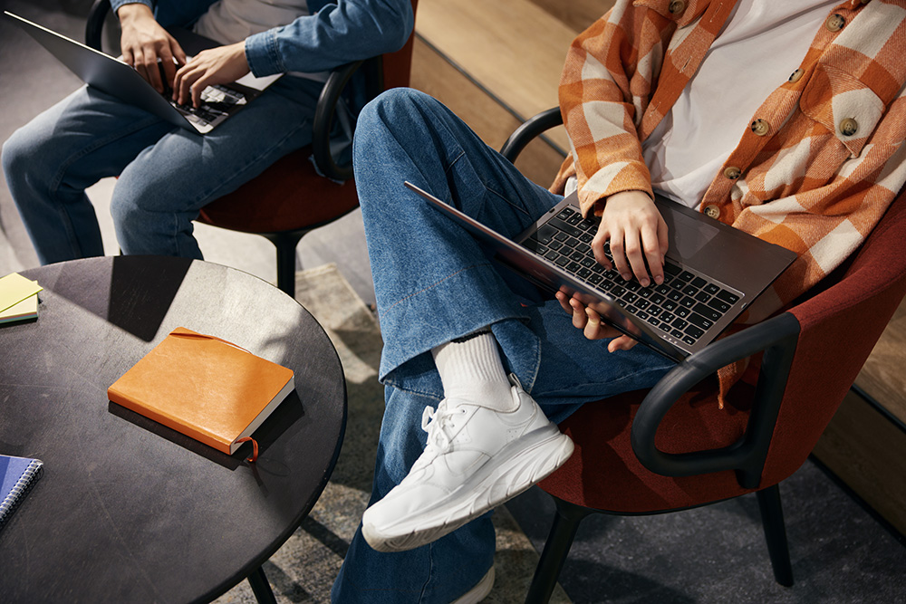two people sitting in a chair with a laptop