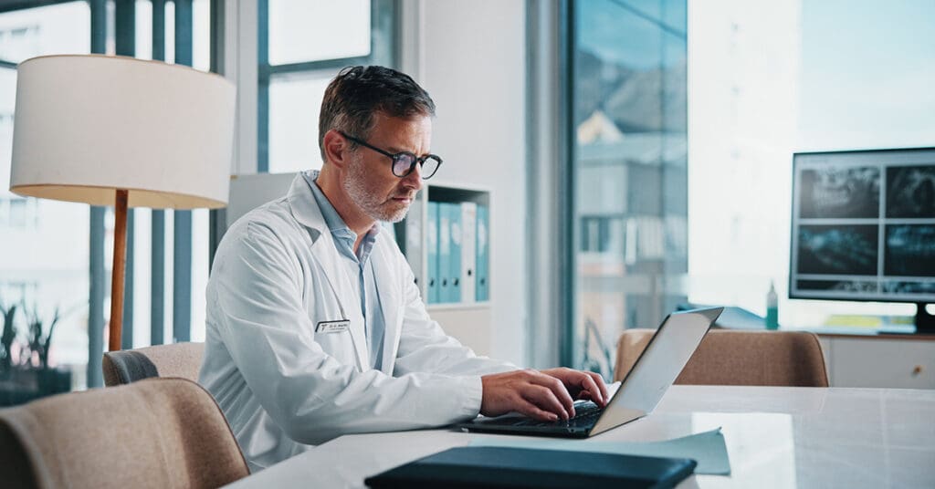 Doctor on a laptop learning how to create a healthcare website design that patients love